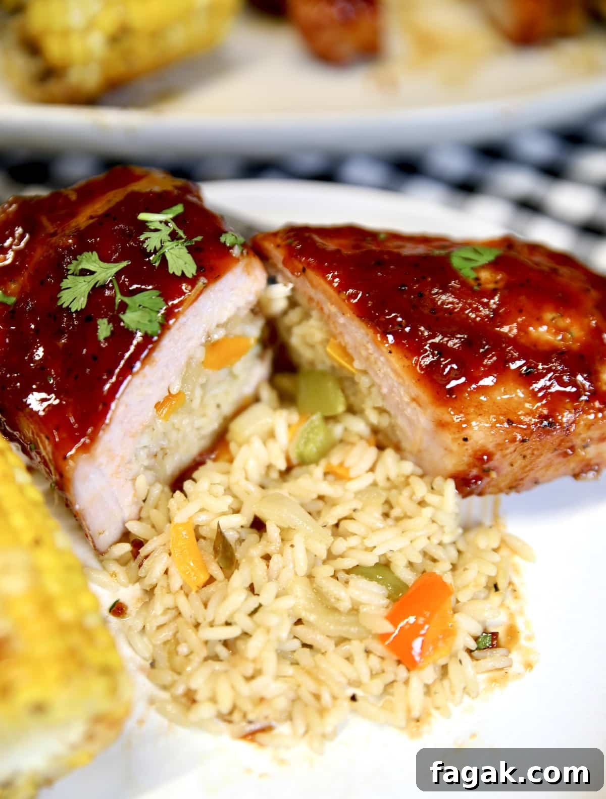 Pork chop with rice pilaf and corn on a plate.