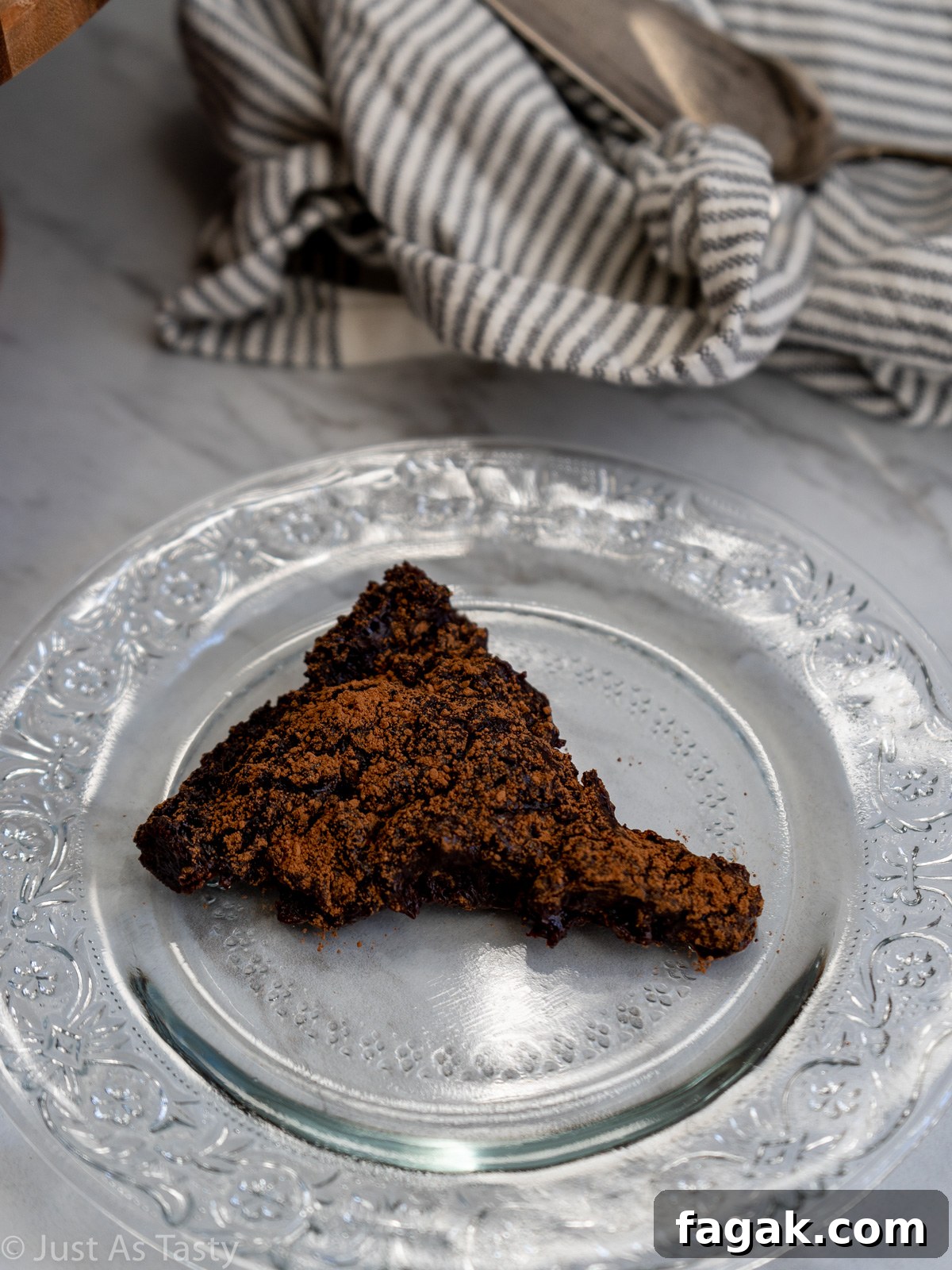 Slice of flourless chocolate cake on a glass plate.
