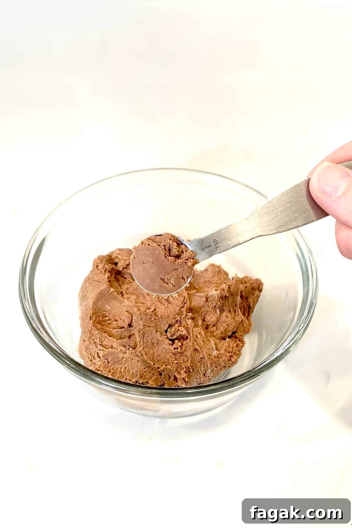 Scooping out heaping teaspoonfuls of batter.