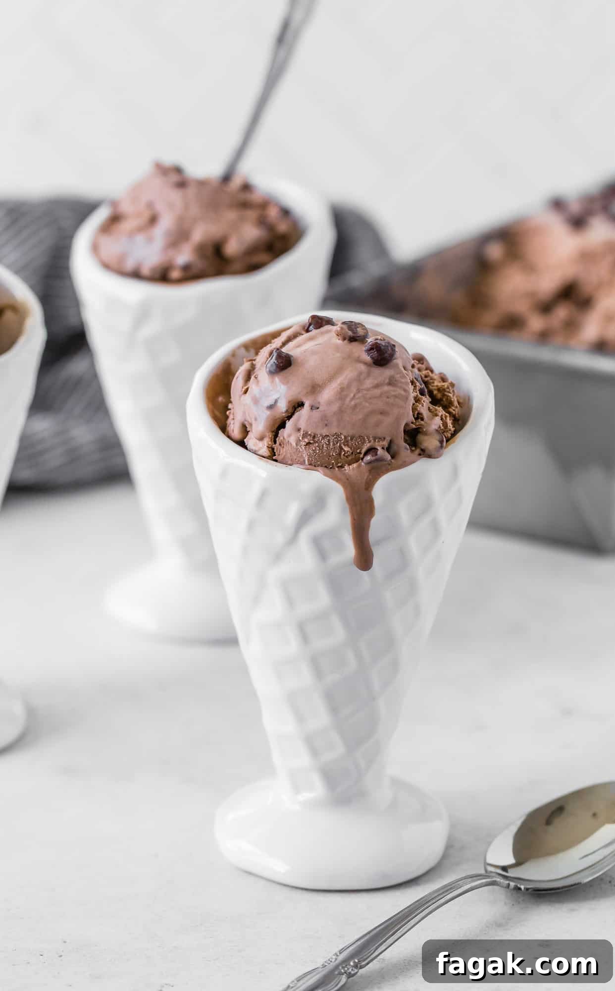 Chocolate ice cream dripping down a white ceramic cone.