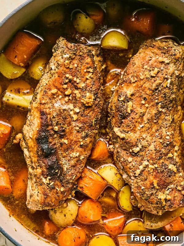 Dutch oven with roasted pork tenderloin, carrots and potatoes.