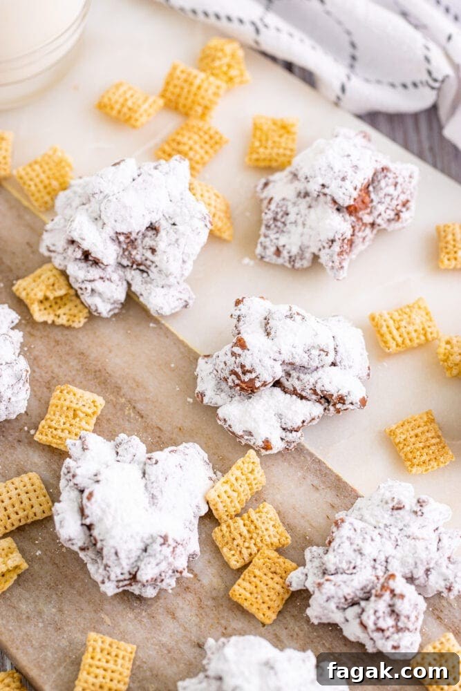 Powdered cranberry krispy treats resembling Muddy Buddy Cookies on a cutting board.