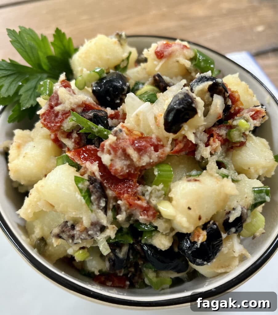 Italian potato salad with parsley garnish in white bowl with black rim.