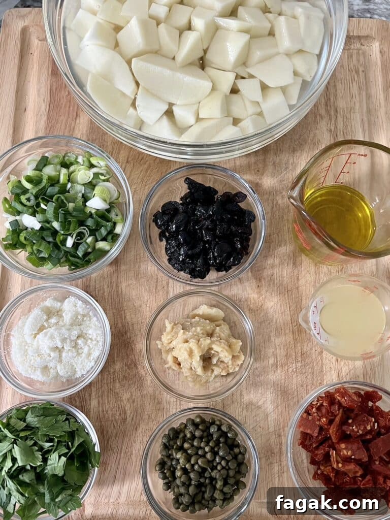 All prepped ingredients for potato salad without mayo in glass bowls.